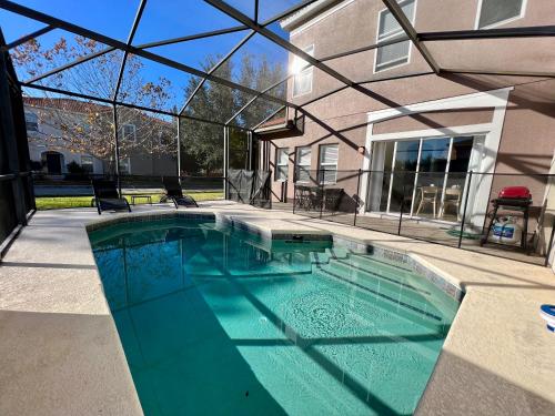 a swimming pool in front of a house at Four Bedroom w/ Screened Pool Close to Disney 4572 in Kissimmee