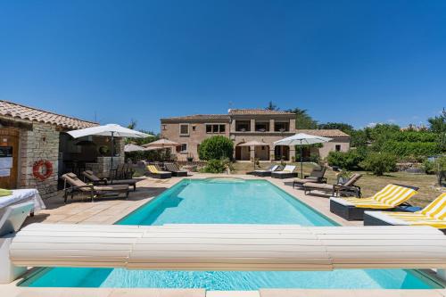 a swimming pool with chairs and a house at Mon Ventoux - Cozyhotes in Sault-de-Vaucluse