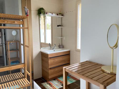 a bathroom with a sink and a mirror and a table at Ô Clair de Lune Chambres d'hôtes climatisées à Sarlat - parking privé - piscine chauffée - espace bien-être Jacuzzi et massages in Sarlat-la-Canéda