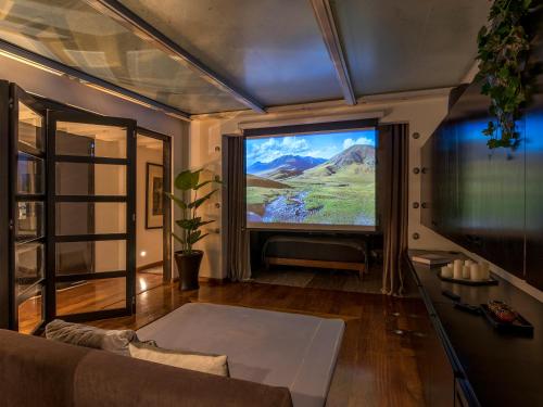 a living room with a large tv and a couch at Grand Cinema & Jacuzzi Appartment in Mexico City