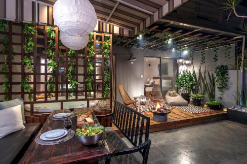 a patio with a table and chairs and a room with plants at Grand Cinema & Jacuzzi Appartment in Mexico City