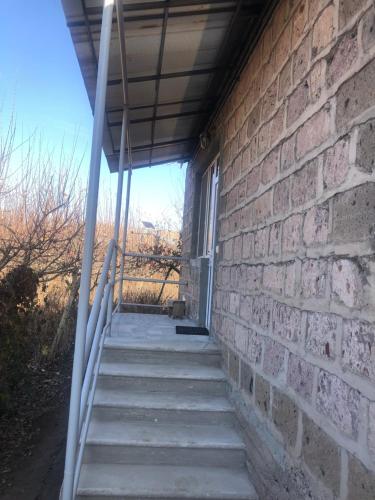 a staircase leading to a brick wall with a window at Norik guest house in Garni