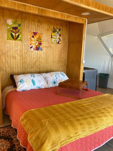 een slaapkamer met een bed met een tafel erop bij Domo con tinaja, Estaquilla in Los Muermos