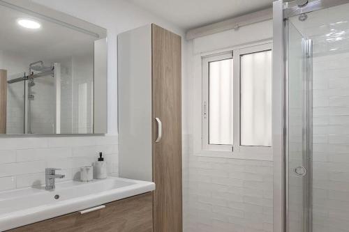 La salle de bains blanche est pourvue d'un lavabo et d'une douche. dans l'établissement Casa La Granatilla, San José, à San José