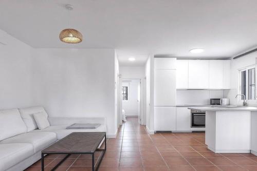Il comprend un salon avec un canapé blanc et une cuisine. dans l'établissement Casa La Granatilla, San José, à San José
