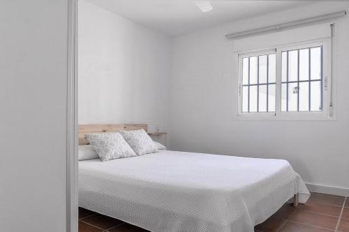 - une chambre blanche avec un lit et une fenêtre dans l'établissement Casa La Granatilla, San José, à San José