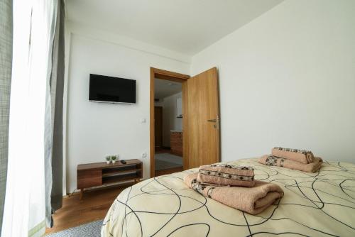 a bedroom with a large bed with towels on it at Apartman La Foresta Kopaonik in Kopaonik
