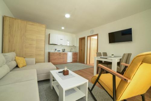 a living room with a couch and a table at Apartman La Foresta Kopaonik in Kopaonik