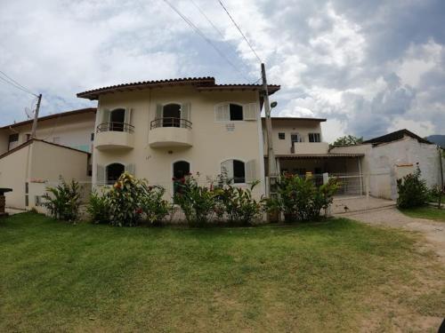 una gran casa blanca con un patio delante en CASA UBATUBA-MARANDUBA, casa térrea, en Ubatuba