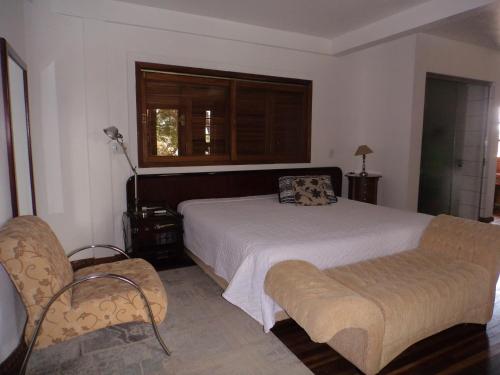a bedroom with a bed and a couch and a window at ROSA CORTIANA Escalera in São Gabriel