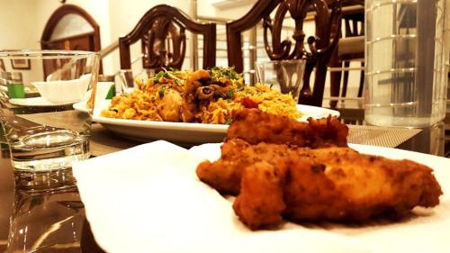 a plate of food on a table with a plate of food at Hayyat Luxury Hotel Apartments in Lahore
