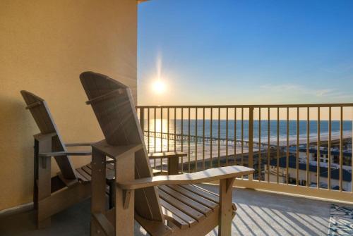 two chairs on a balcony with a view of the beach at Oceanview 3BR Near Pier Park, Pool and Hot Tub in Panama City Beach
