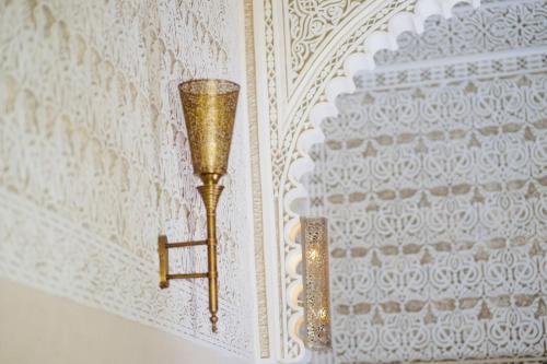 a lamp hanging on a wall in a room at Riad Amelia : Lalla Nora Room in Tetouan