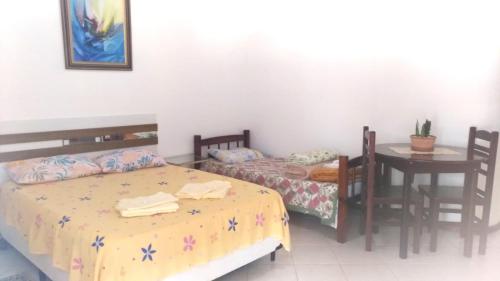 a bedroom with two beds and a table and a table and chairs at Pousada Montanha da Pedra Grande in Atibaia