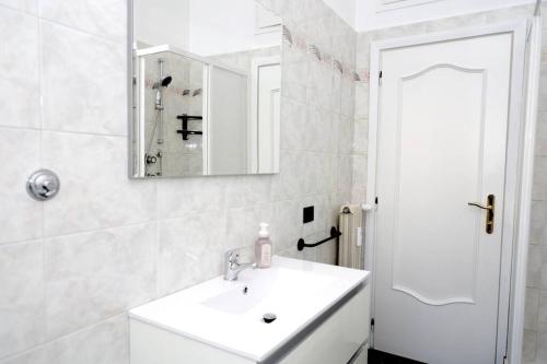 ein weißes Badezimmer mit einem Waschbecken und einem Spiegel in der Unterkunft The Libra Nordic Home in Rom