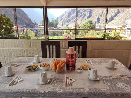 a table with food on it with a view of a mountain at Hostal EL VIAJERO en Ollantaytambo in Ollantaytambo