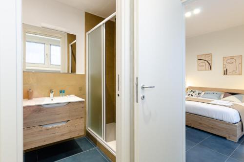 VELASQUEZ APARTMENTS - A - San Siro في ميلانو: حمام مع مغسلة وسرير في الغرفة