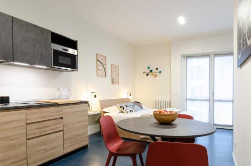 a kitchen and a table in a room with a bed at VELASQUEZ APARTMENTS - A - San Siro in Milan