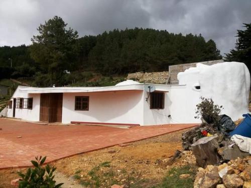 a small white house with a dirt yard at Casa Mujer Villa Agueda in Chocontá