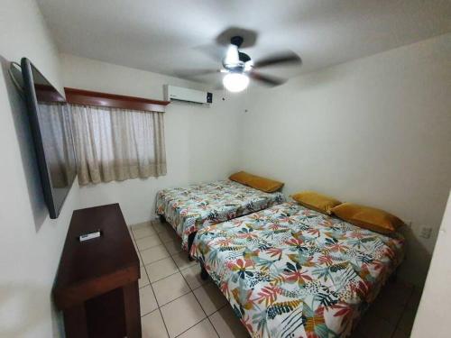 1 dormitorio con 2 camas y ventilador de techo en Central Departamento, en Mazatlán