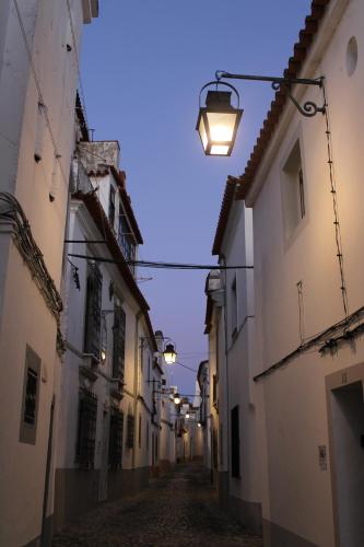 een steegje met een straatlicht tussen twee gebouwen bij Casa Refúgio in Évora