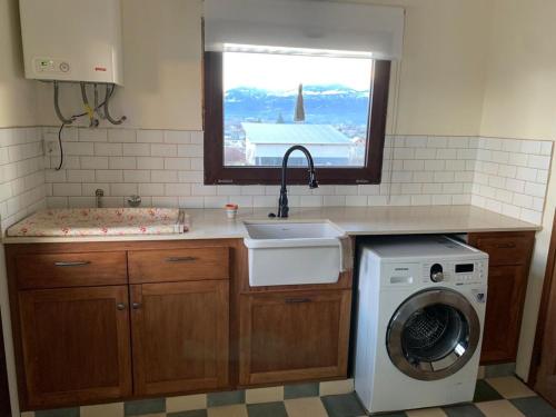 a kitchen with a sink and a washing machine at Espectacular casa en Trevelin. in Trevelin
