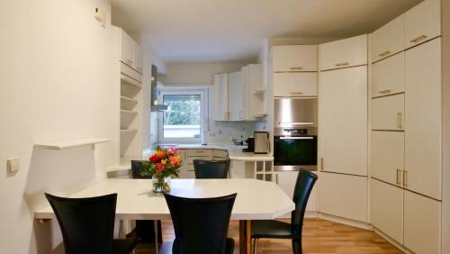 eine Küche mit einem weißen Tisch und Stühlen in einem Zimmer in der Unterkunft Hotel Pegasus in München