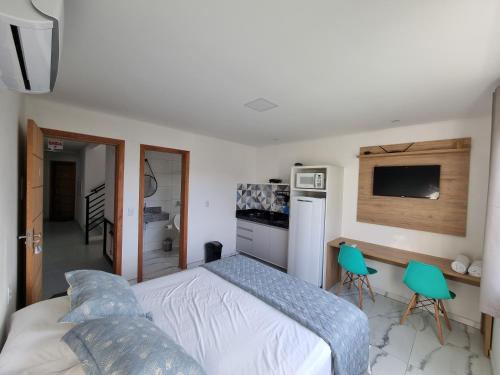 a bedroom with a bed and two green chairs at Águas de Canto Grande in Bombinhas