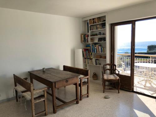 une salle à manger avec une table et des chaises et un balcon dans l'établissement Appartement Cassis Plage, à Cassis