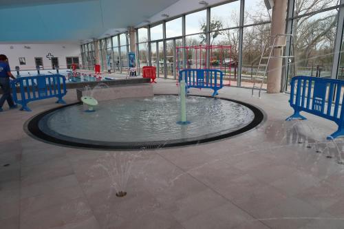 a water fountain in a building with two blue benches at Le Sophora in Chéu