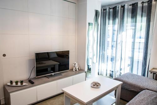 uma sala de estar branca com uma televisão e uma mesa em Rota Mar em Rota