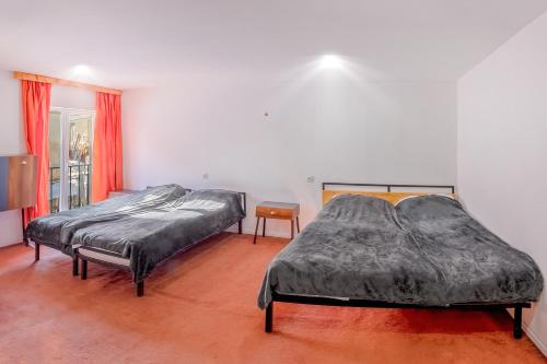 two twin beds in a room with red curtains at sweet dreams bakuriani in Bakuriani