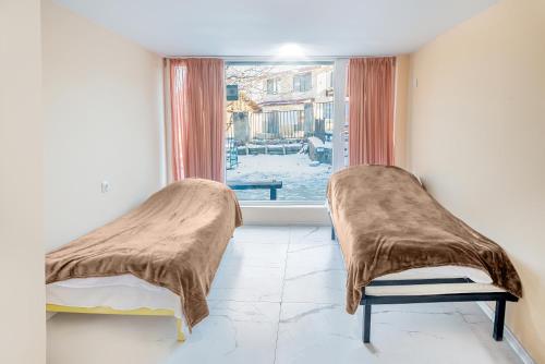 two beds in a room with a window at sweet dreams bakuriani in Bakuriani