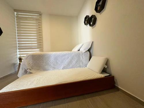 a bed sitting in a room with a window at Casa AMAR·i·LLA Chantepec in Chantepec