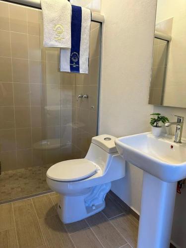 a bathroom with a white toilet and a sink at Casa AMAR·i·LLA Chantepec in Chantepec
