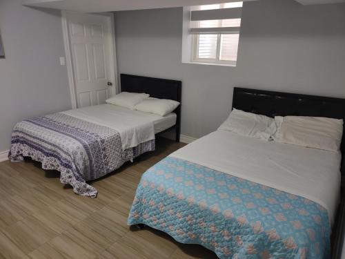 a bedroom with two beds and a bedskirts at Prestige Accommodation Self-contained 2 Bedrooms Suite in Ajax