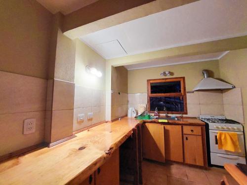 a kitchen with a wooden counter top and a stove at Monoambiente en la Montaña - De Alojamientos Lago Puelo in Lago Puelo