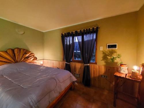 a bedroom with a large bed and a window at Monoambiente en la Montaña - De Alojamientos Lago Puelo in Lago Puelo