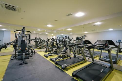 a gym with a lot of treadmills and ellipticals at Gori Inn in Gori