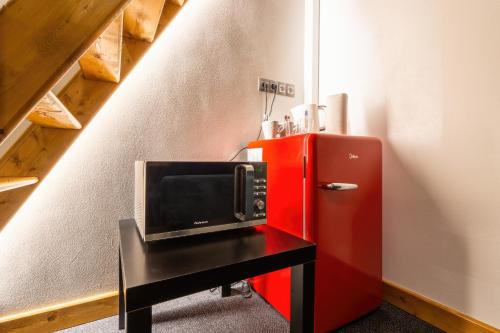 a microwave on a table next to a red refrigerator at S42 Hotel Prague in Prague