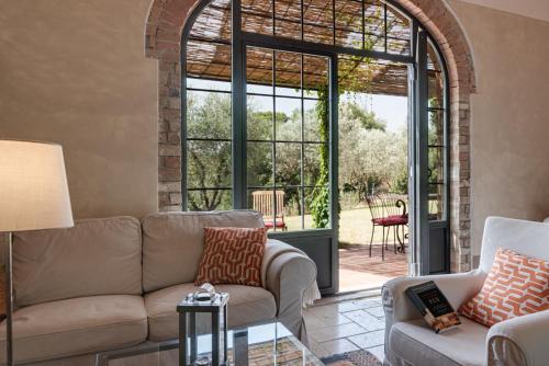 a living room with a couch and a large window at Podere Ferranino at Ville Ferrano in San Giovanni dʼAsso