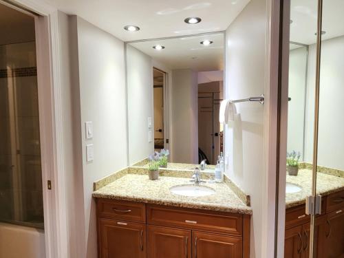 a bathroom with two sinks and a large mirror at 1BR Ski In Ski Out Cozy Condo w Pool and Hot Tub by Harmony Whistler in Whistler