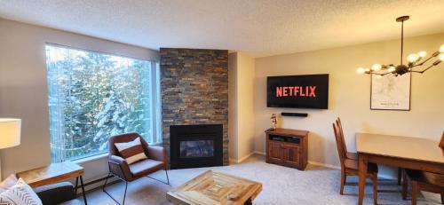 a living room with a table and a fireplace at 1BR Cozy Condo w Pool and Hot Tub by Harmony Whistler in Whistler