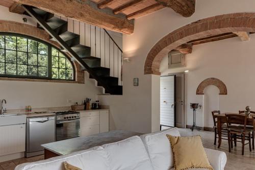 a kitchen and living room with a white couch at Podere Ferranino at Ville Ferrano in San Giovanni dʼAsso