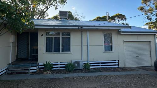 a small white house with a garage at Home away from home in Merredin