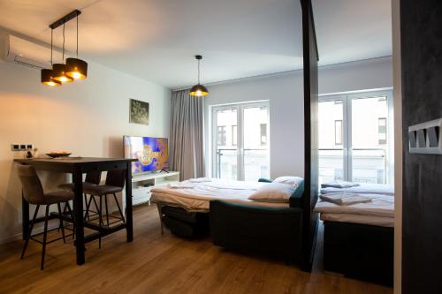 a bedroom with a bed and a table and a desk at Sunny Apartment Lwowska 10 in Kraków