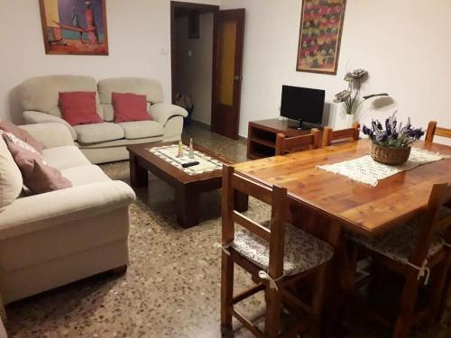 sala de estar con sofá y mesa en Casa Rural El Rincón de Diego en La Puebla de Valverde