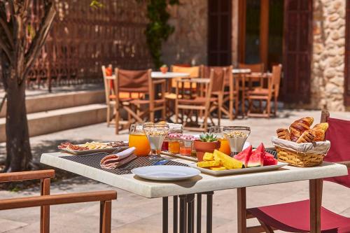 アラロにあるCa' n Beia Suites - Adults Onlyの食べ物と飲み物のトレイが並ぶテーブル
