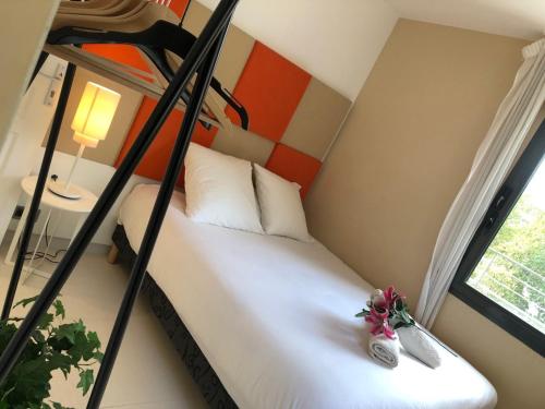 um quarto com uma cama com dois sapatos e uma janela em Appartement montfleury, 2 terrasses, 2 chambres , 2 sdb , pkg privé piscine, 15 min walk to Croisette beach and Palais des festivals em Cannes