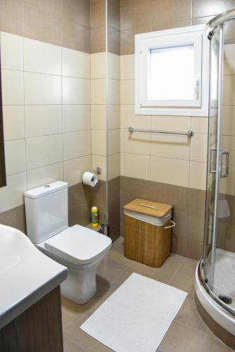 a bathroom with a toilet and a shower and a window at Lux apartment & stunning view in Kavála